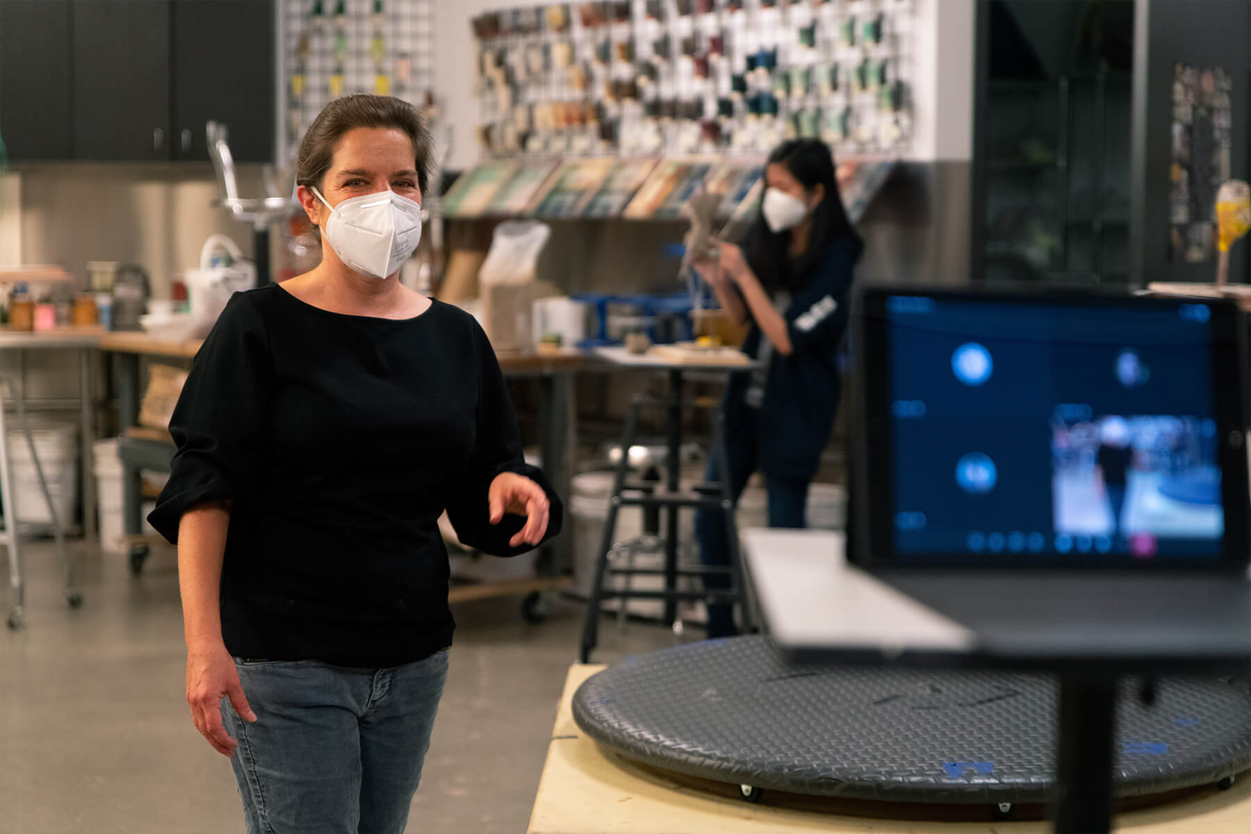 Woman wearing a mask teaches a class by video.