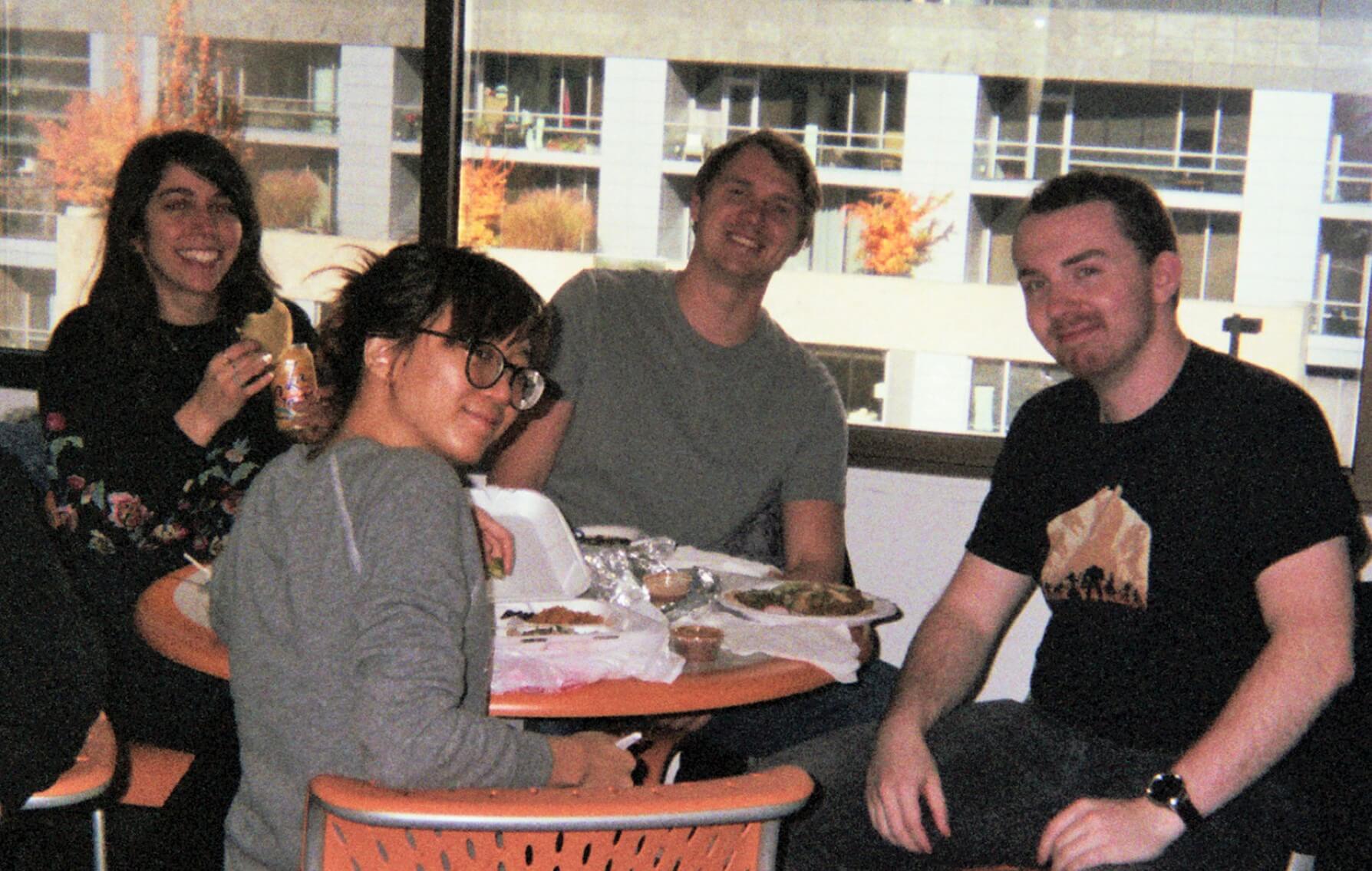 Four people eating lunch at a table.