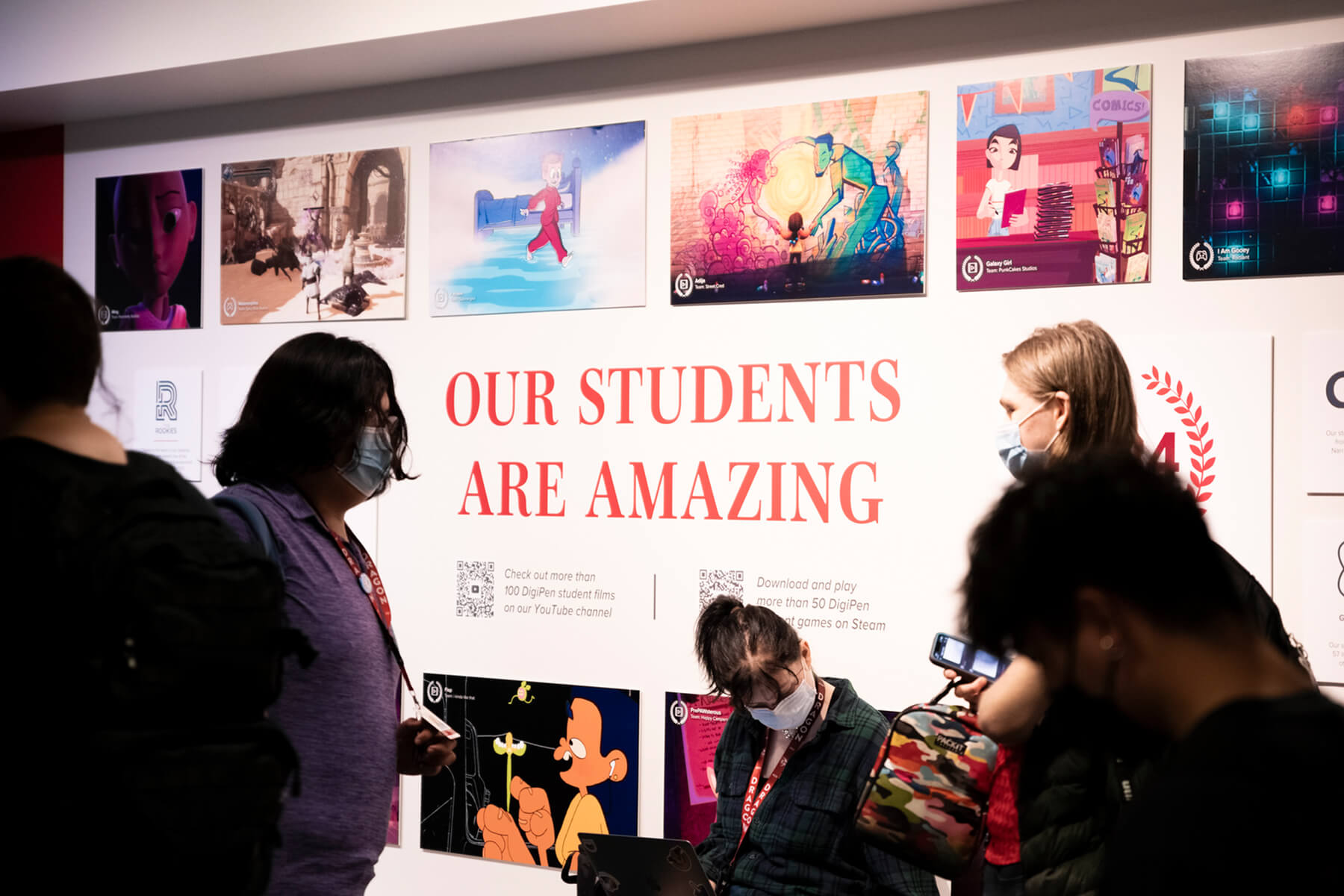 Students gather in front of a display that reads “Our Students are Amazing” on DigiPen’s campus.