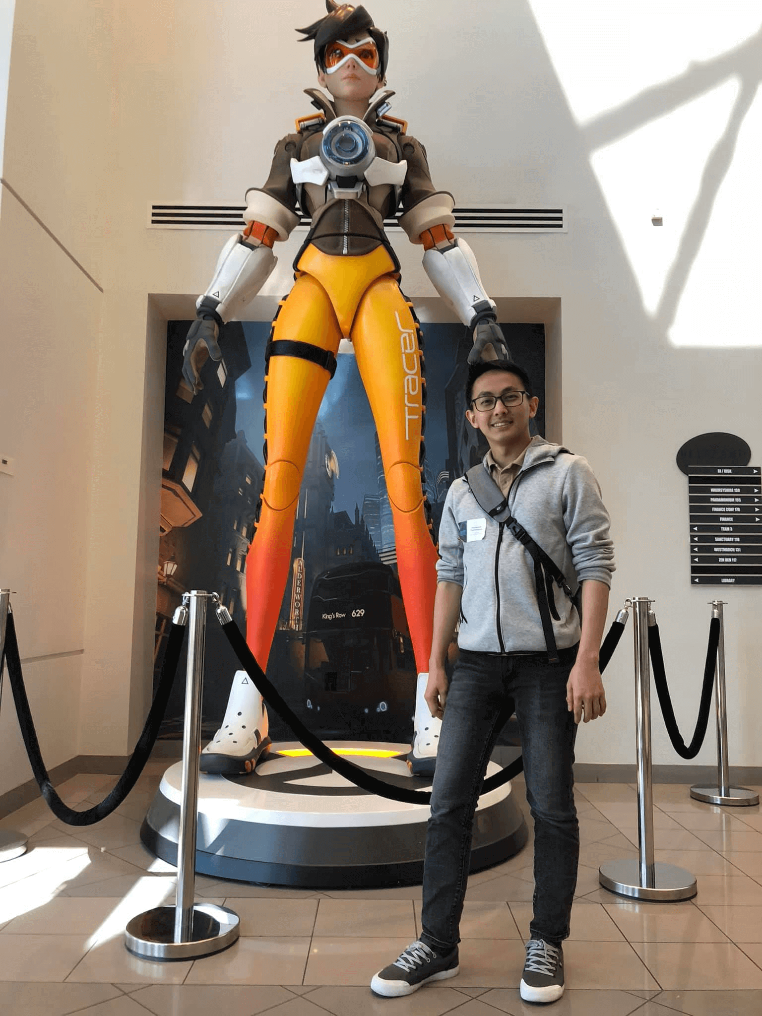 Chonlawat “Takki” Thammawan poses in front of a giant statue of the Overwatch 2 character Tracer.