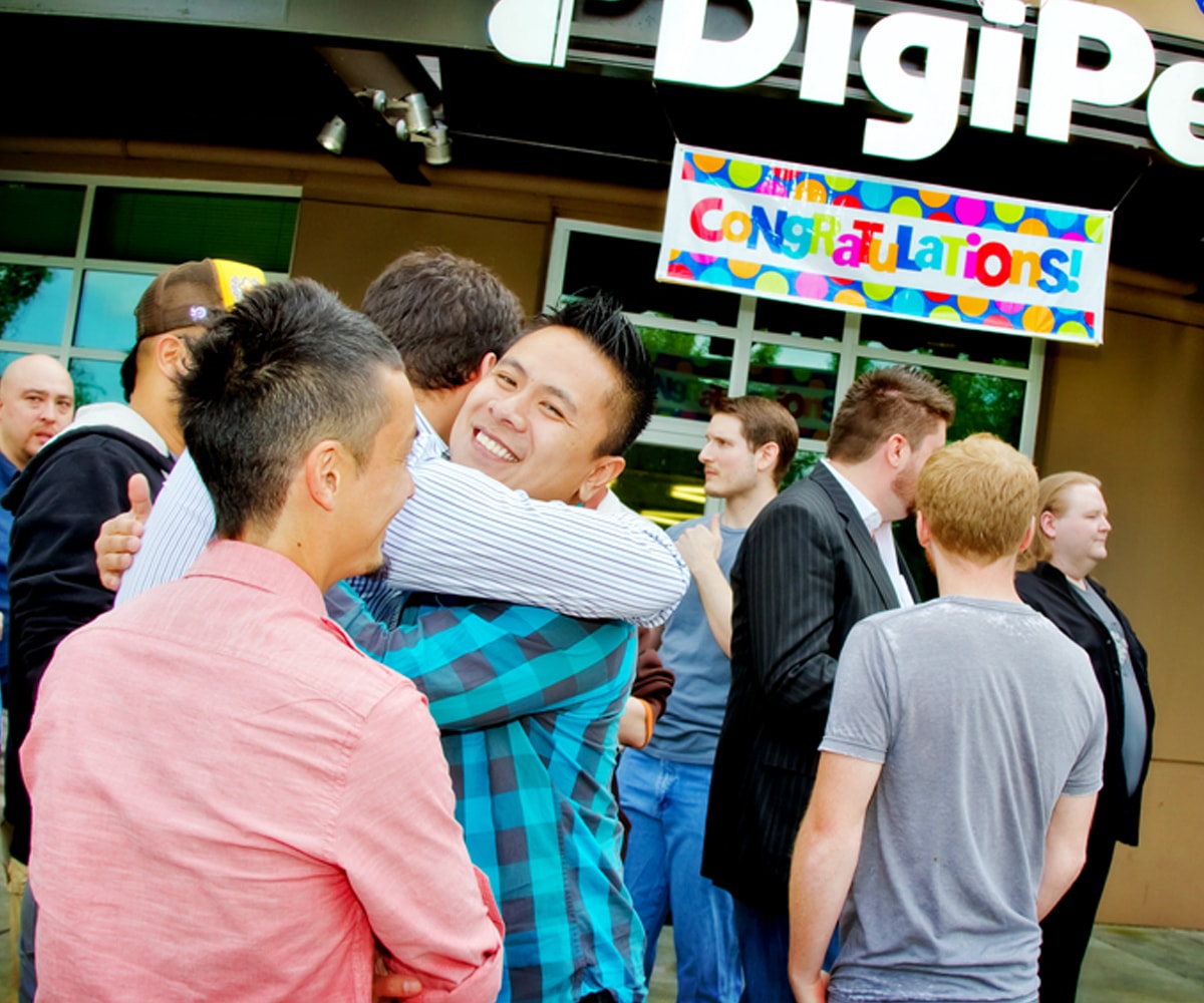 Alumni hug in front of the DigiPen building