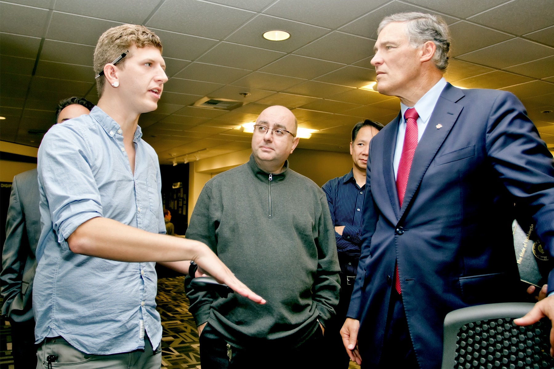 DigiPen student Joshawa Salyers gesturing as he speaks with Governor Jay Inslee and Claude Comair