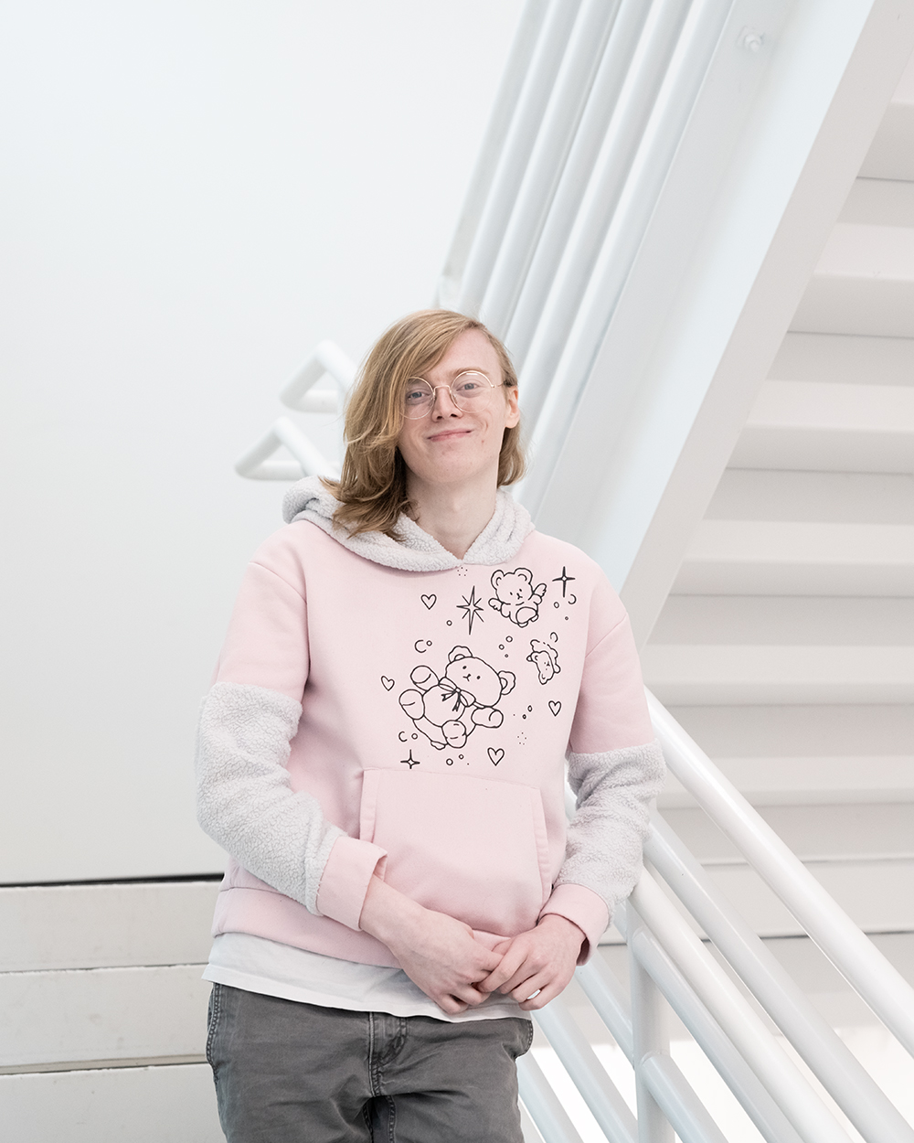 DigiPen student Tetra Chaney smiles on a white staircase on DigiPen’s campus.