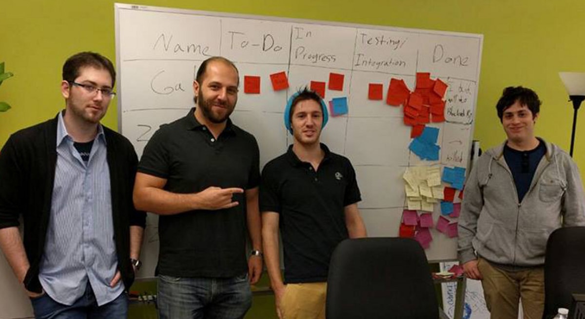 Small group of Tiltan school students in front of a task board at DigiPen