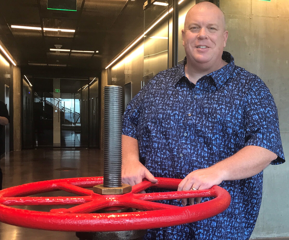 Eric Smith poses with the actual valve at the Valve office