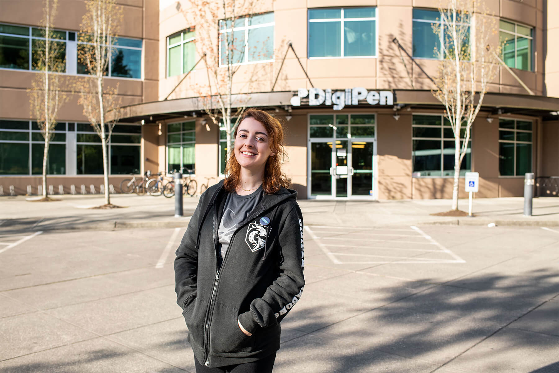 Coelho stands confidently in front of the main entrance at DigiPen's Redmond Campus.