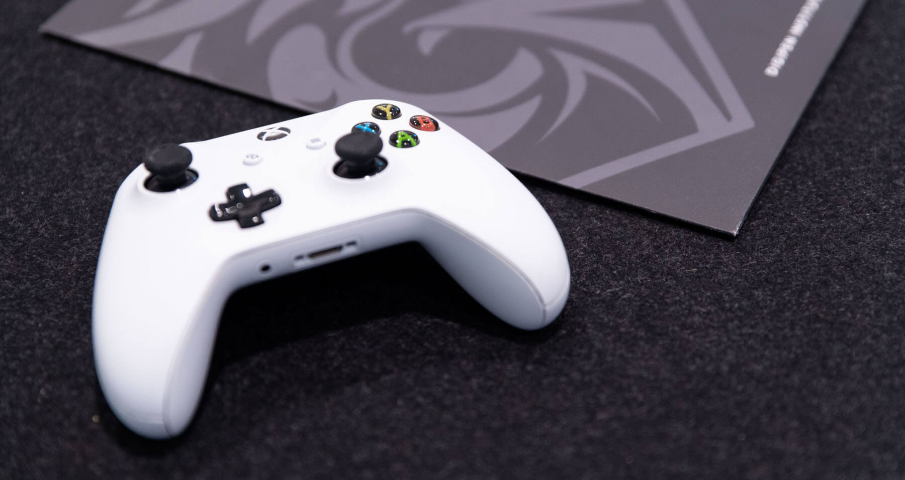 White Xbox controller next to grey DigiPen folder