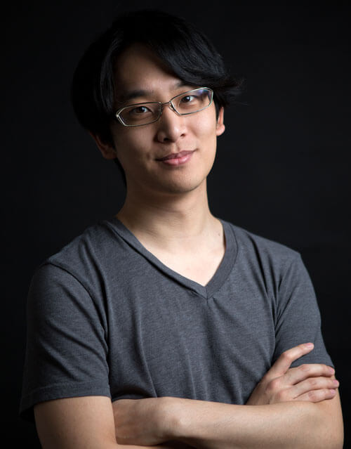 Photograph of Howard Wang smiling set against a black background