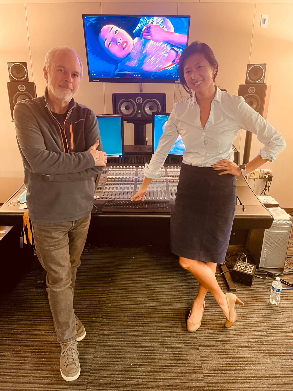 Lawrence Schwedler and Clare Chun stand together in front of studio sound board.