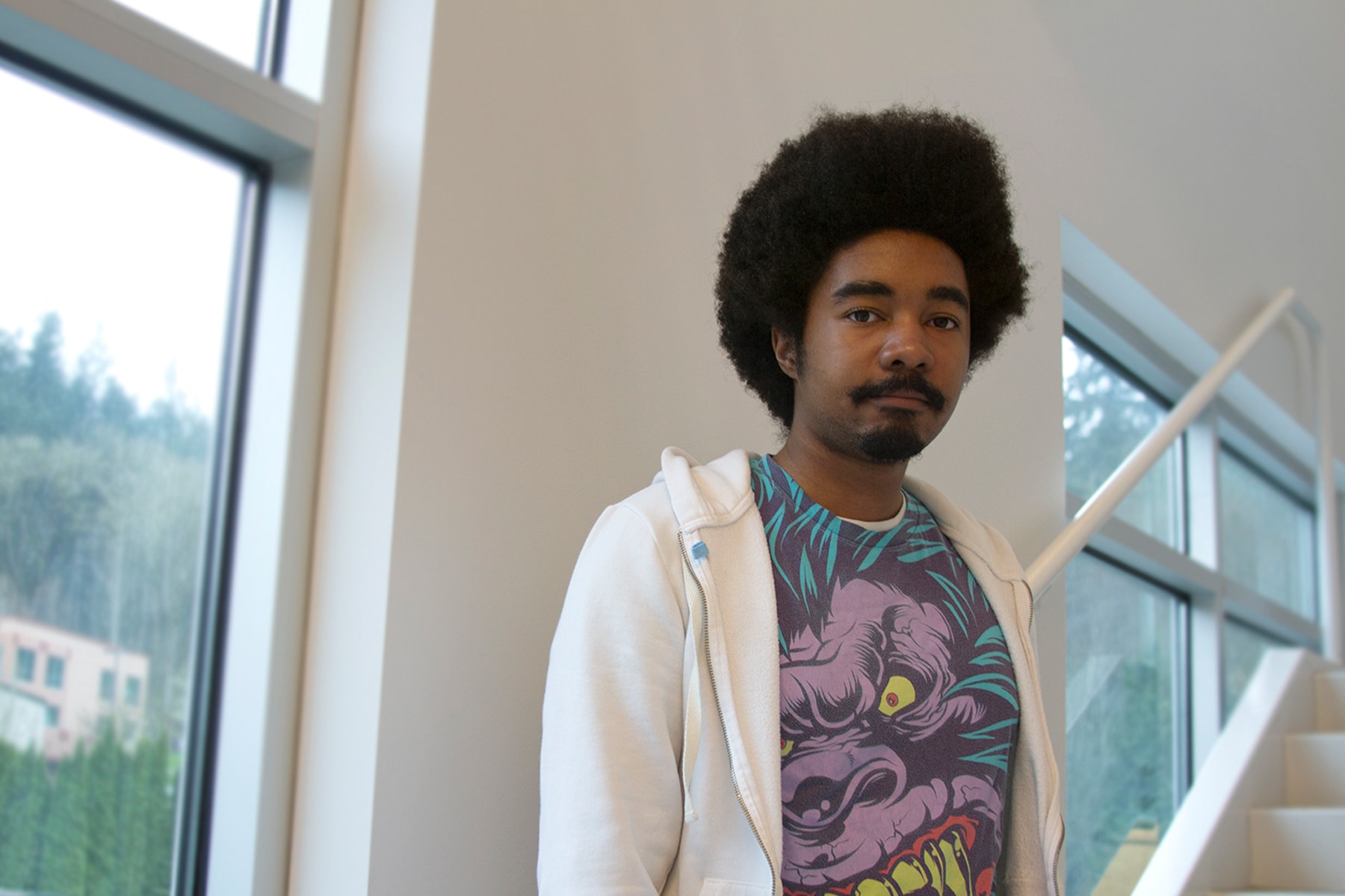 DigiPen student Izzy Abdus Sabur posing in a staircase in the DigiPen building