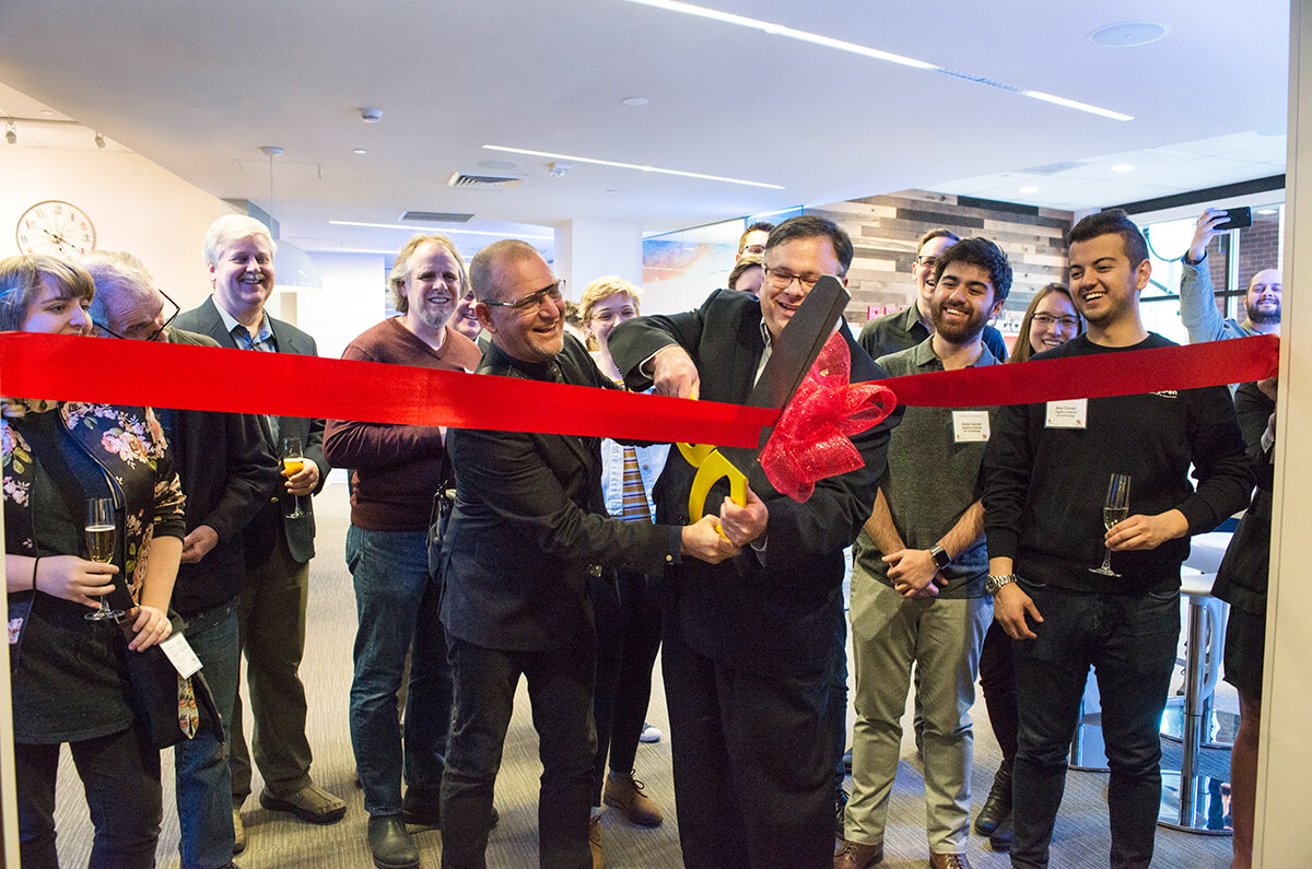 Redmond Mayor John Marchione cuts the ribbon on the new M Space with DigiPen students, faculty, and staff