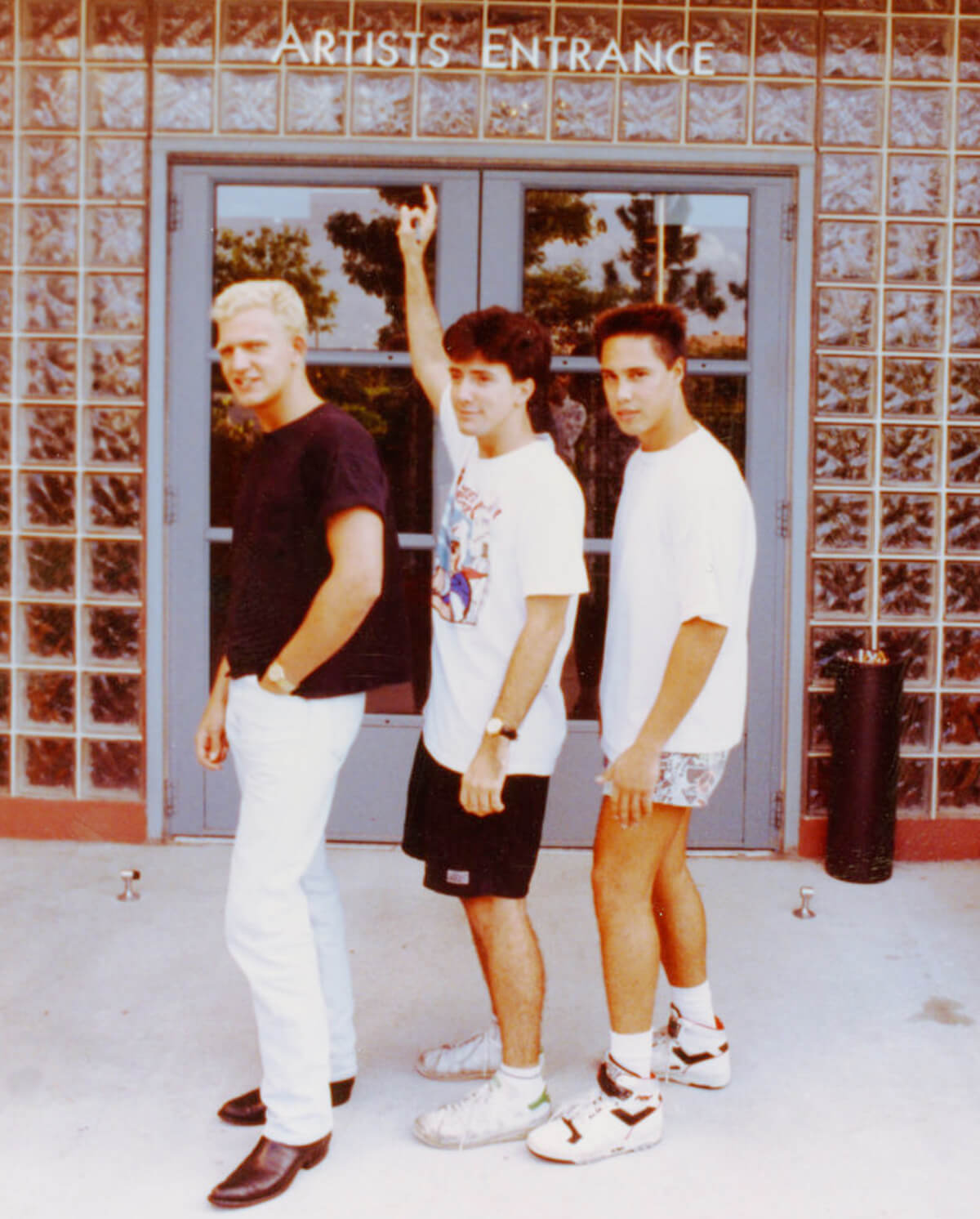 DigiPen BFA director Jazno Francoeur and two co-workers posing in front of the Artists Entrance at Disney Feature Animation Florida