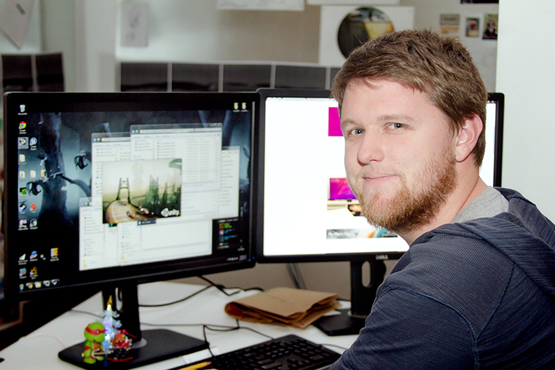 DigiPen computer science graduate Jonathan Gregoire smiling at his desk in the E-Line Media office