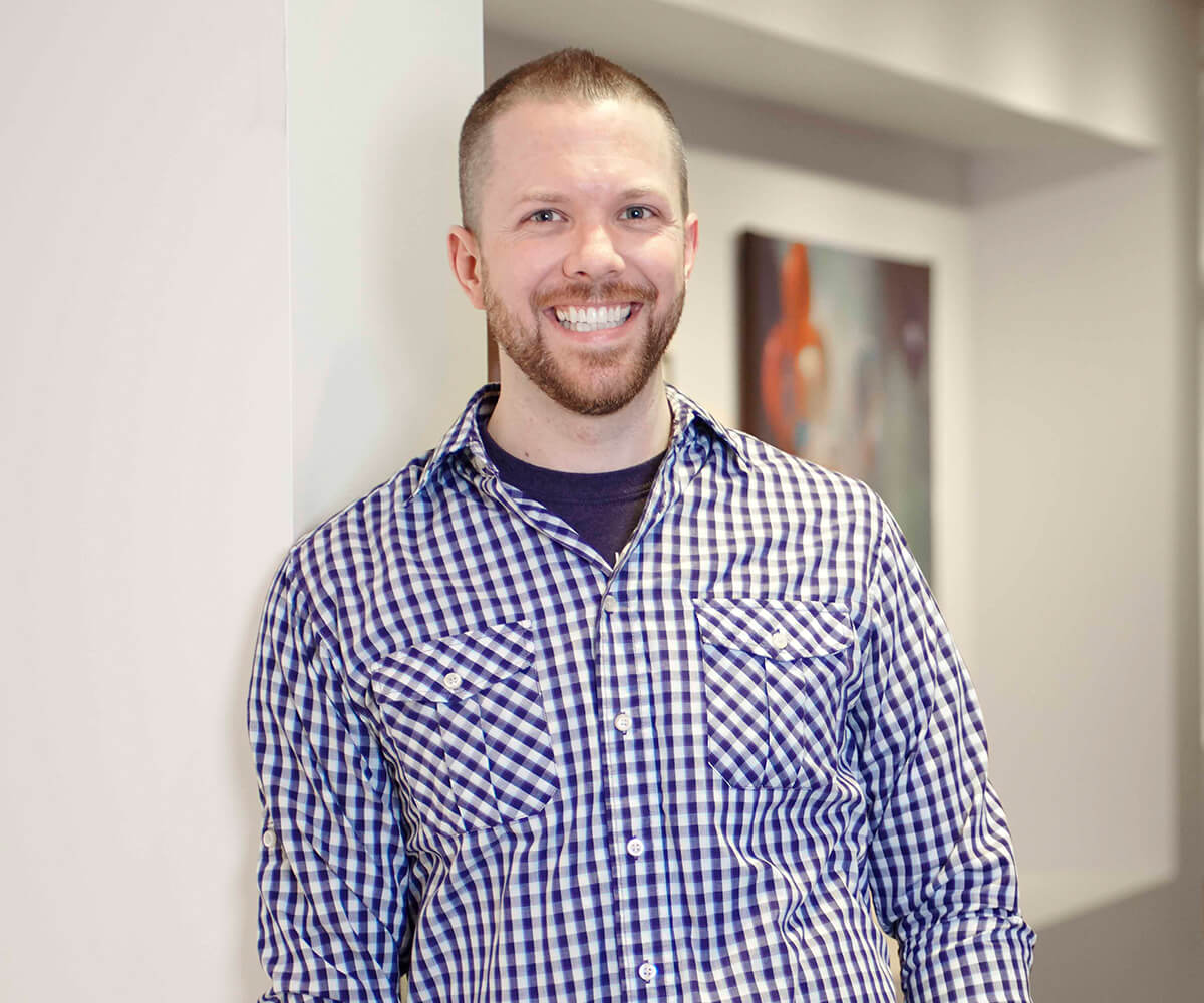 Game Software Design and Production Senior Lecturer Justin Chambers smiles in a DigiPen hallway.