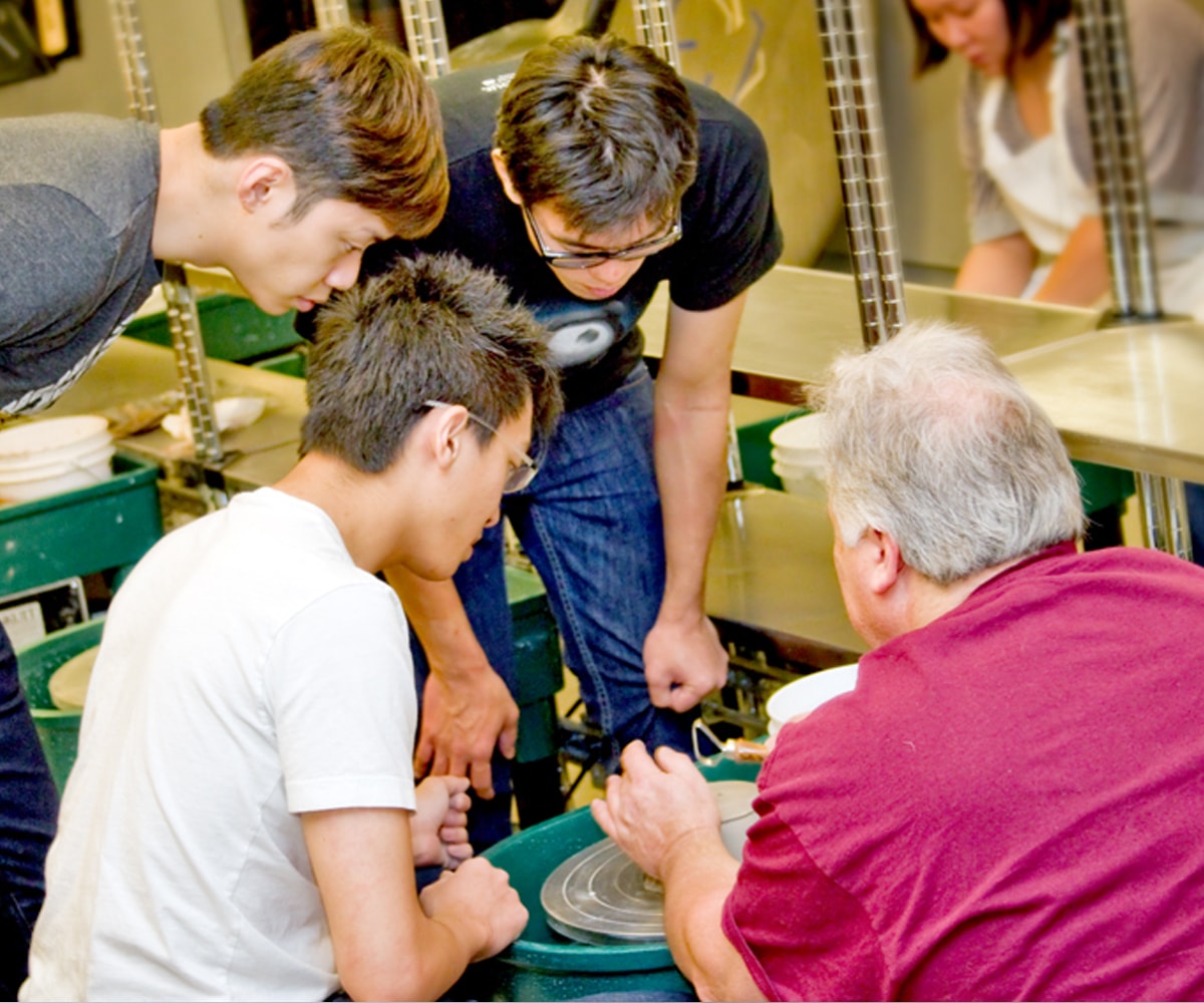 Ken Turner instructs a group of DigiPen students on a ceramics wheel