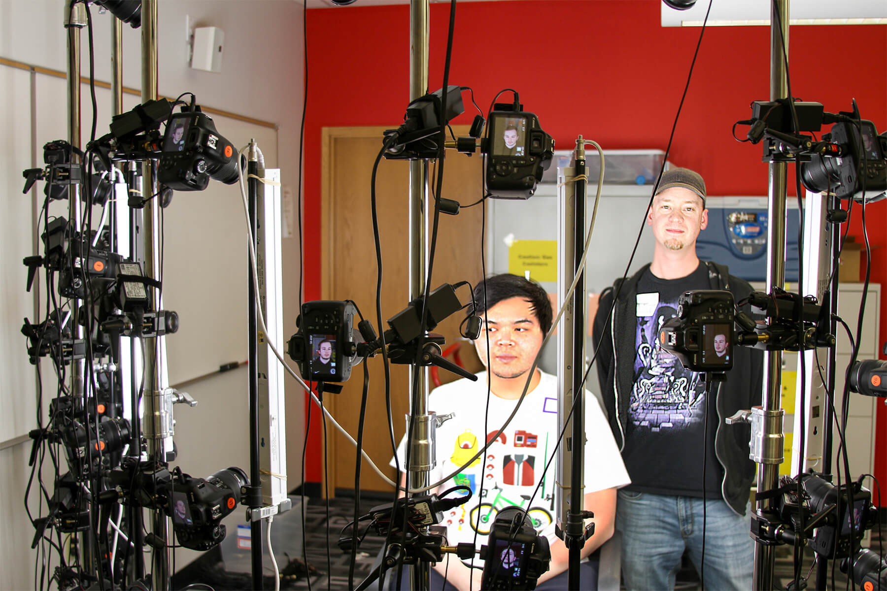 Matt Heiniger poses with a student behind his mobile 40-camera photogrammetry rig. 