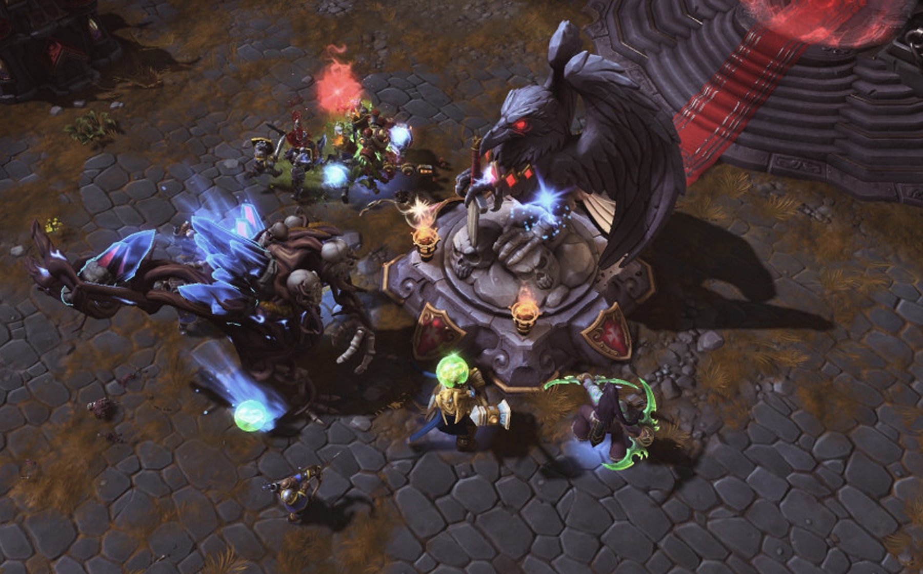 Top-down view of action happening beside a statue of a bird in Heroes of the Storm