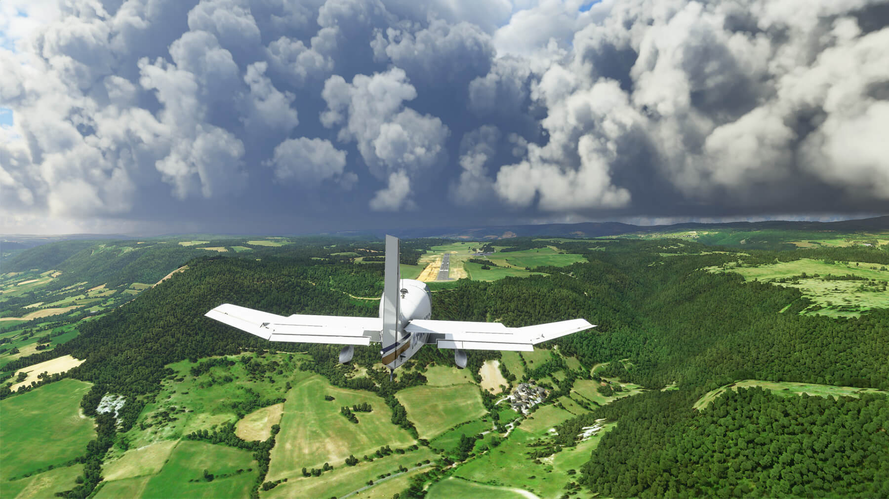 A screenshot from Microsoft Flight Simulator depicting a plane flying over a field with patches of forest.