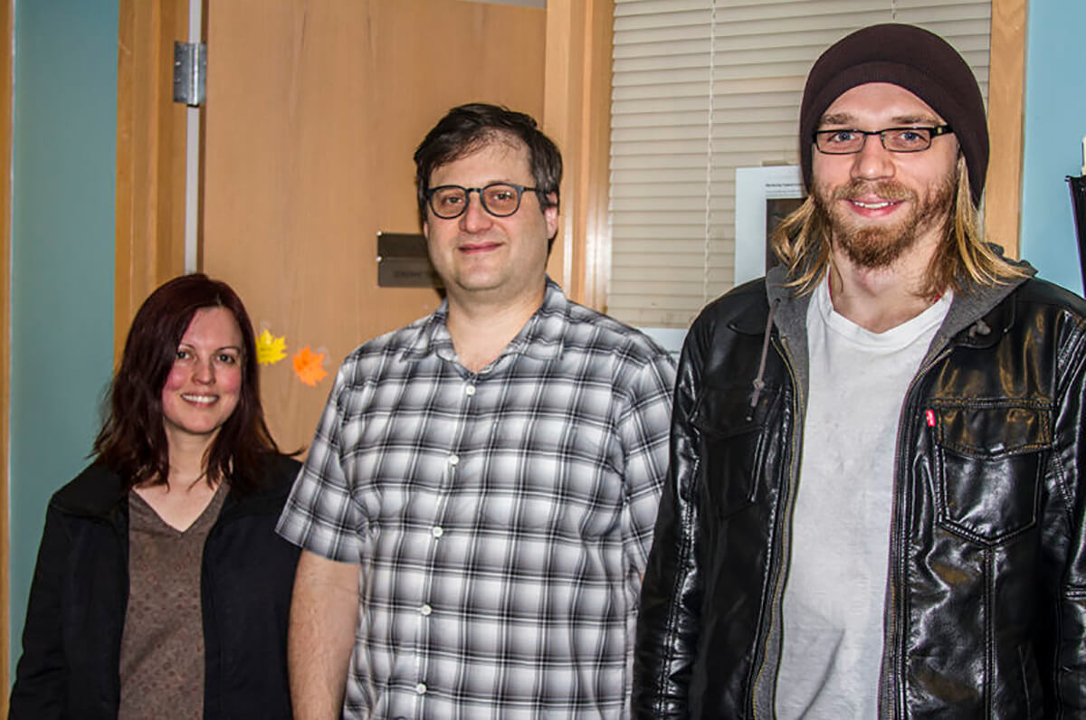 DigiPen professors Natalia Solorzano and Jeremy Thomas pose with alumnus Connor Bracy