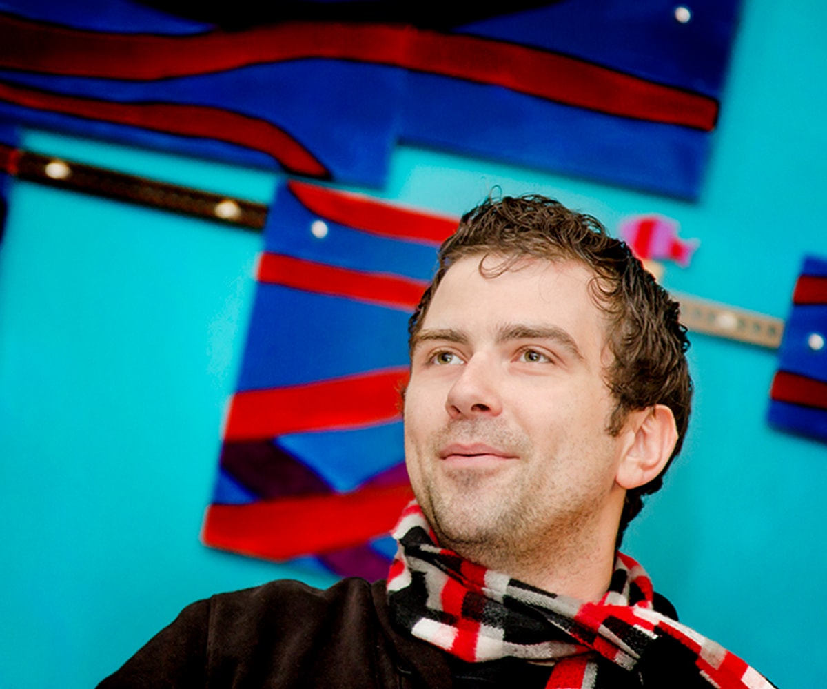 Nate Martin speaking in front of a bright turquoise and red wall