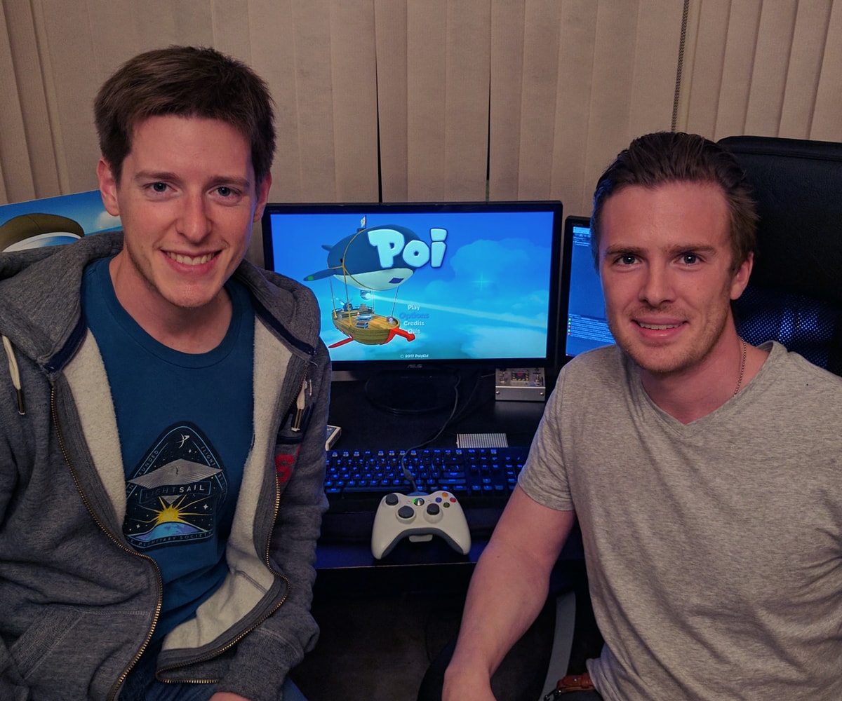 DigiPen alumni Paul Ewers and Ben Gable on launch day, smiling in front of computer monitors diplaying Poi's title screen