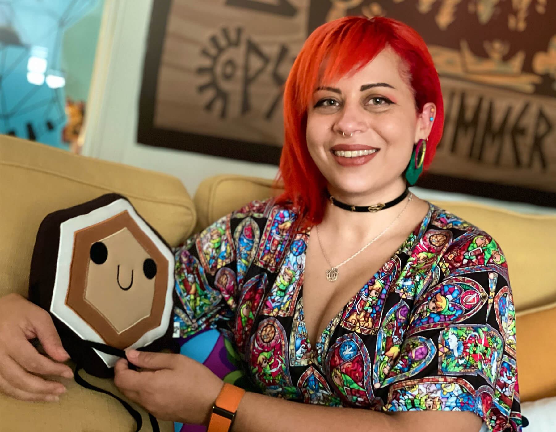 DigiPen alumni Zahra Amirabadi poses in the Double Fine studio with a stuffed animal.