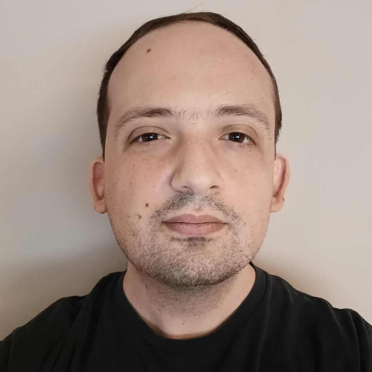 A headshot of DigiPen alumni Randy Totah wearing a black shirt on a white background.