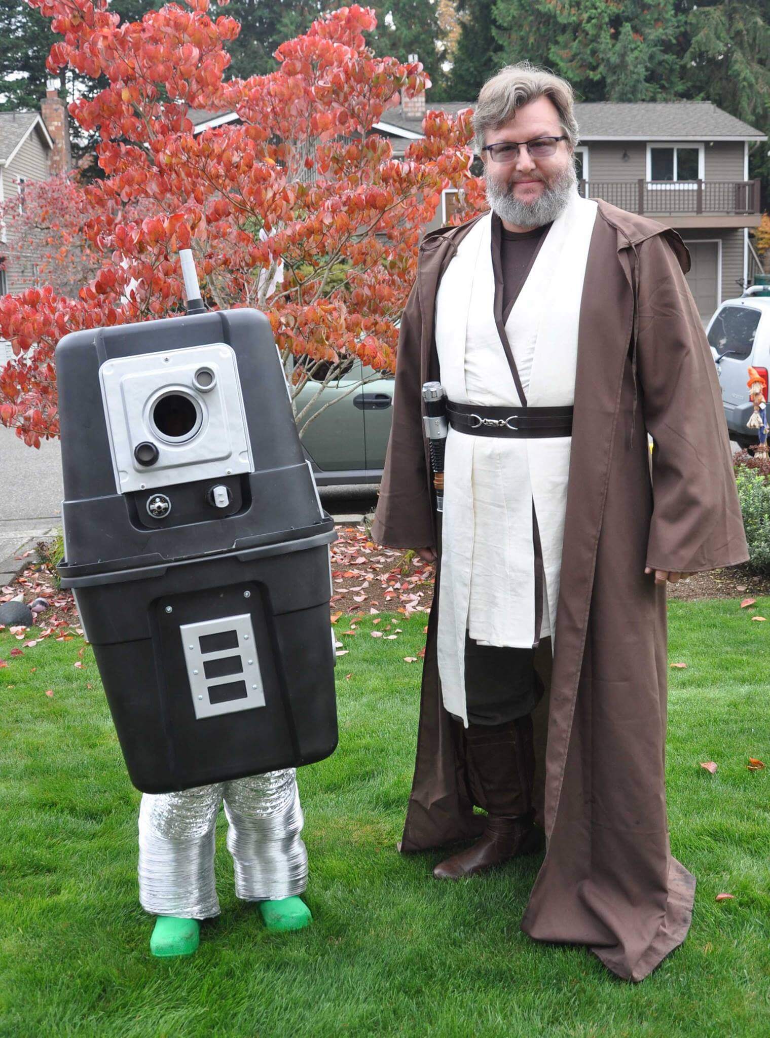 DigiPen Faculty member Bill Morrison dressed as a jedi knight next to his son dressed as a droid pose for a photo
