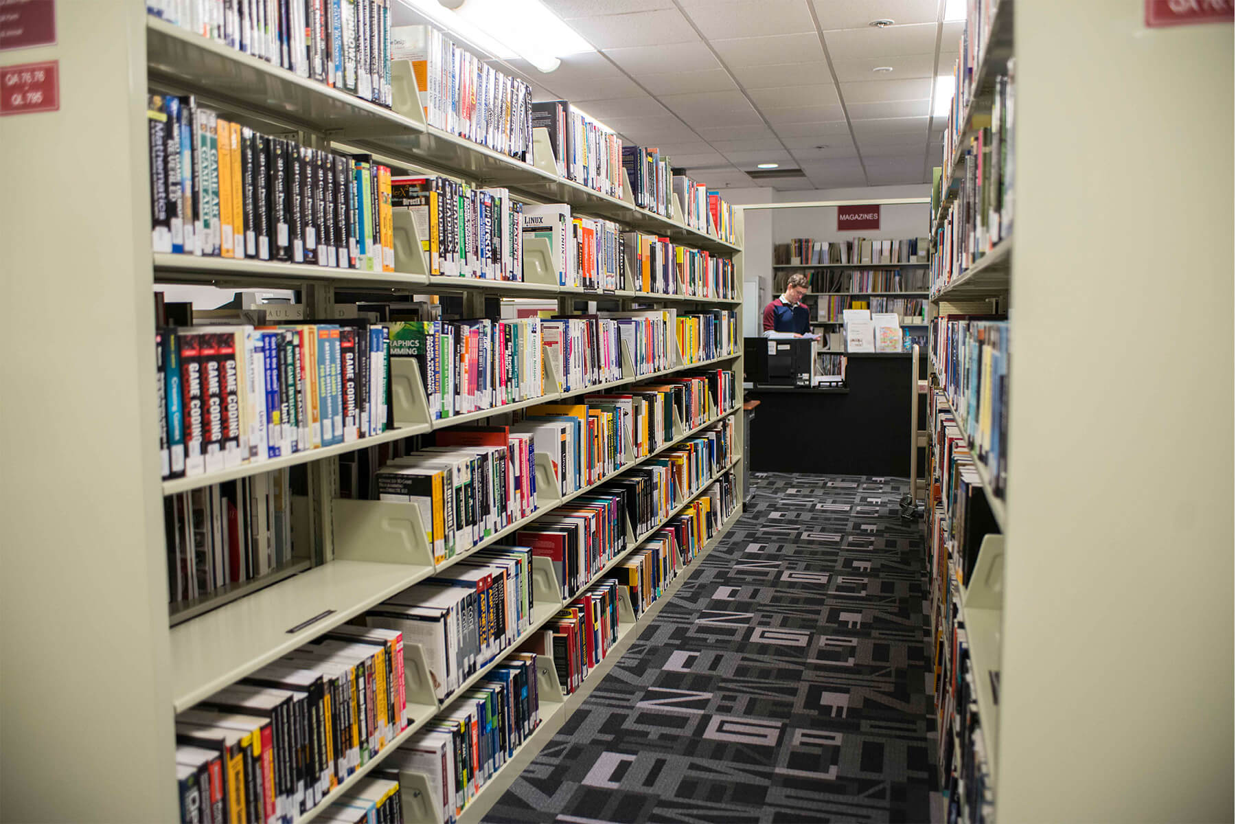 Associate Dean of Learning Technology Resources, Seth Atkinson, behind the counter of the DigiPen library.