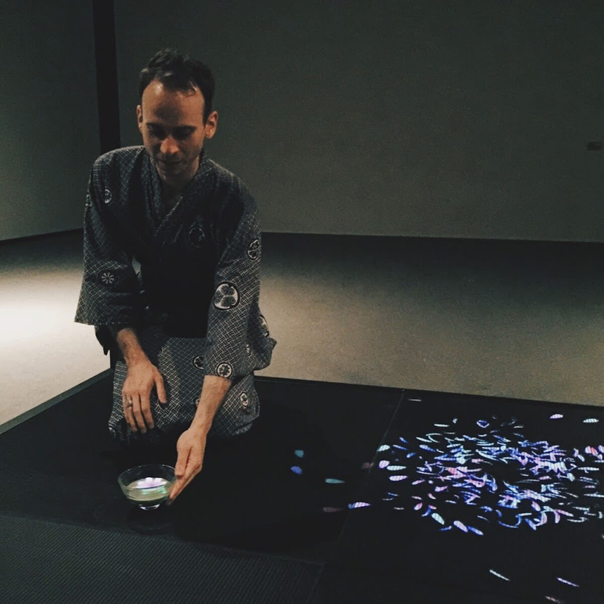 Elliott Davis demonstrates a teamLab artwork with a teacup and virtual flowers.