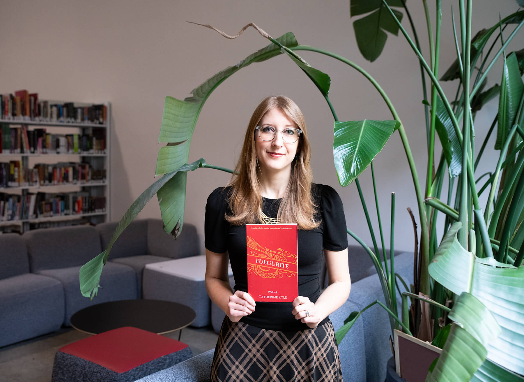 Catherine Broadwall holds up a copy of her book, Fulgurite.