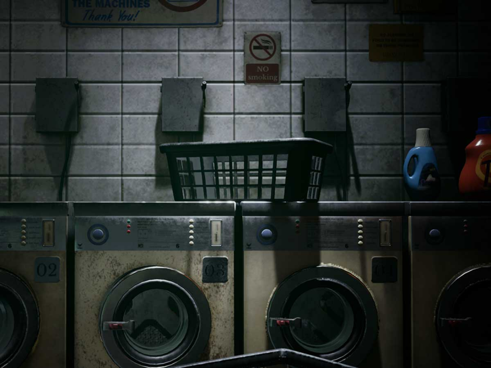 A dark laundromat with empty baskets and laundry cleaning supplies.