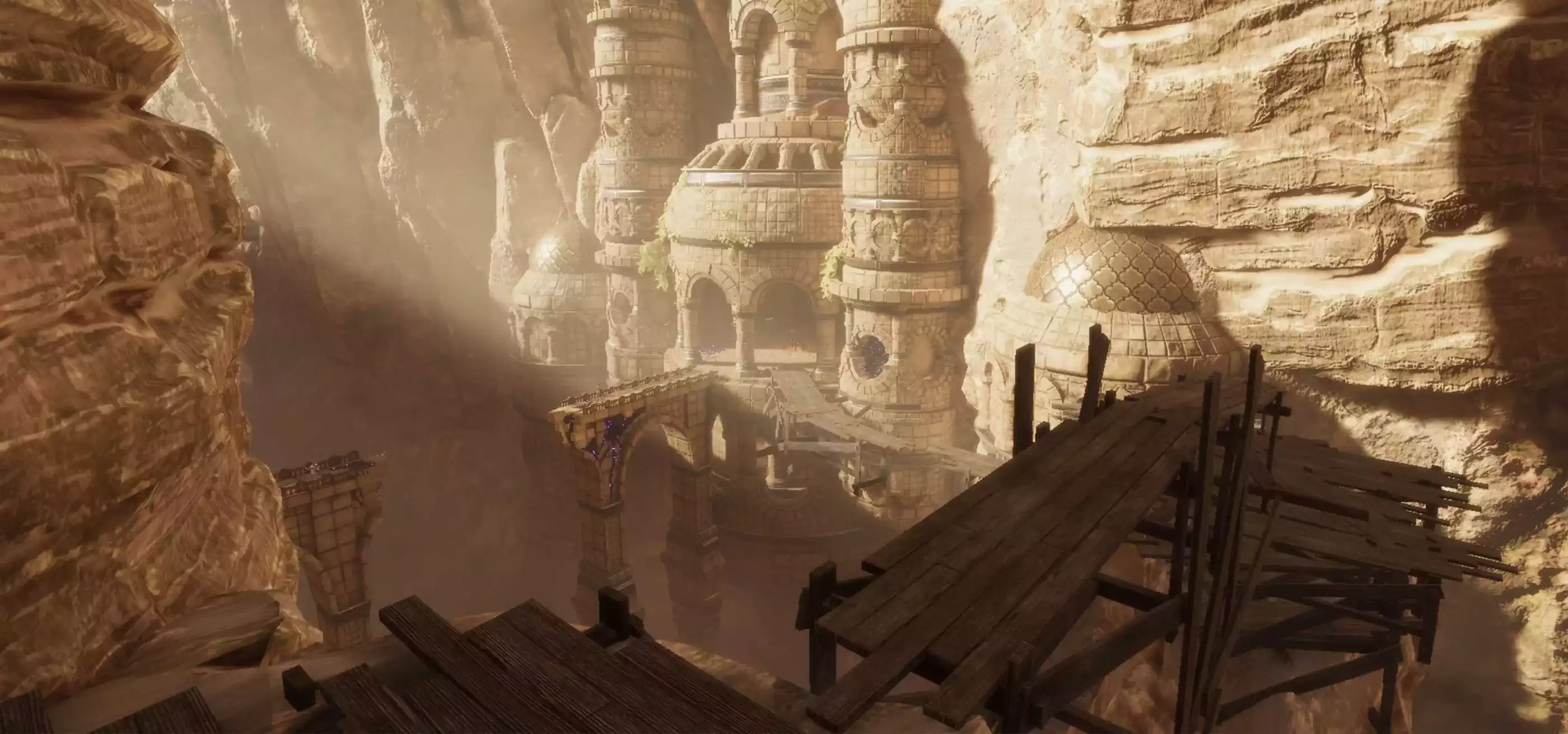 Wooden walkways line the desert canyon amid ancient and crumbling ruins.