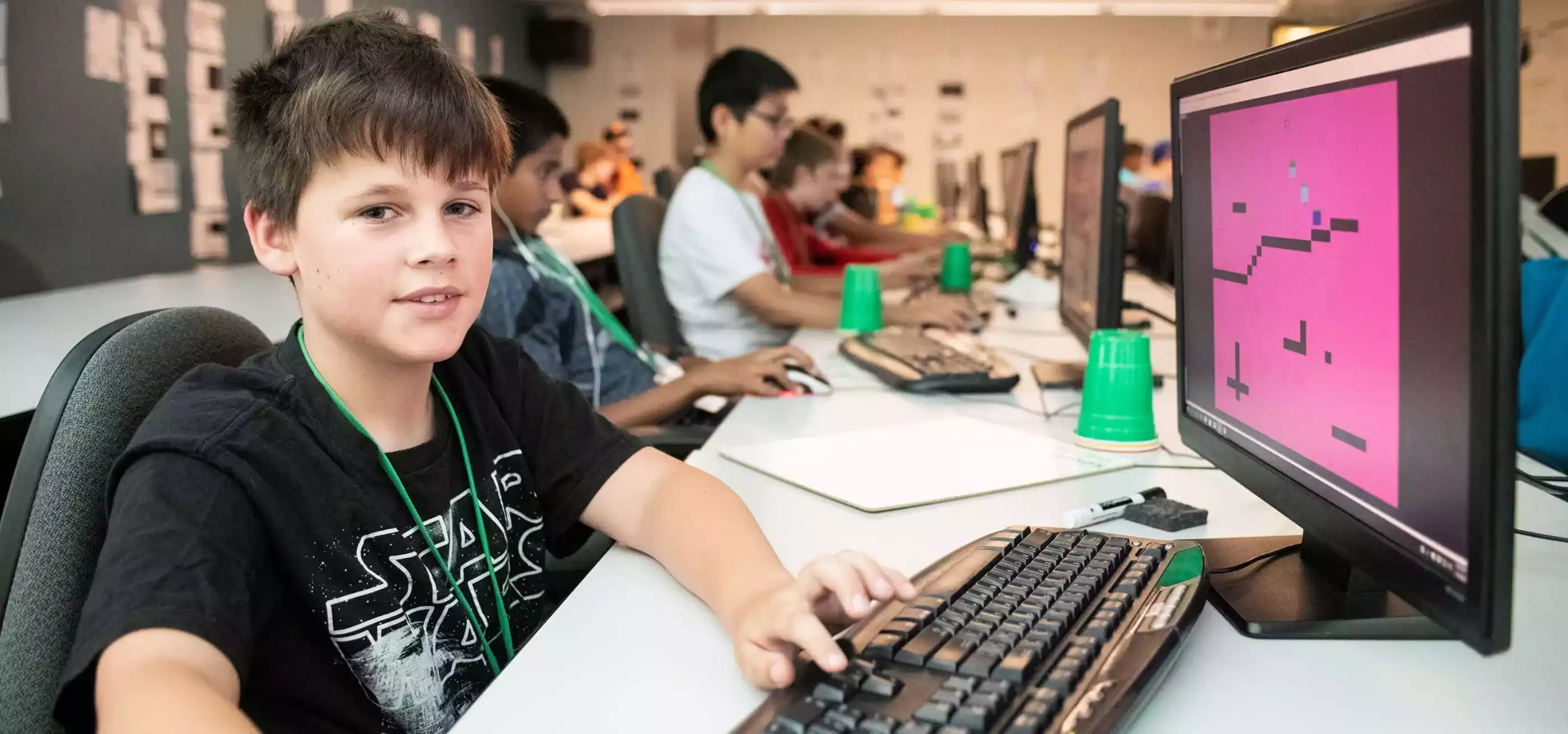 A young DigiPen Academy student sitting in front of a computer on the DigiPen campus