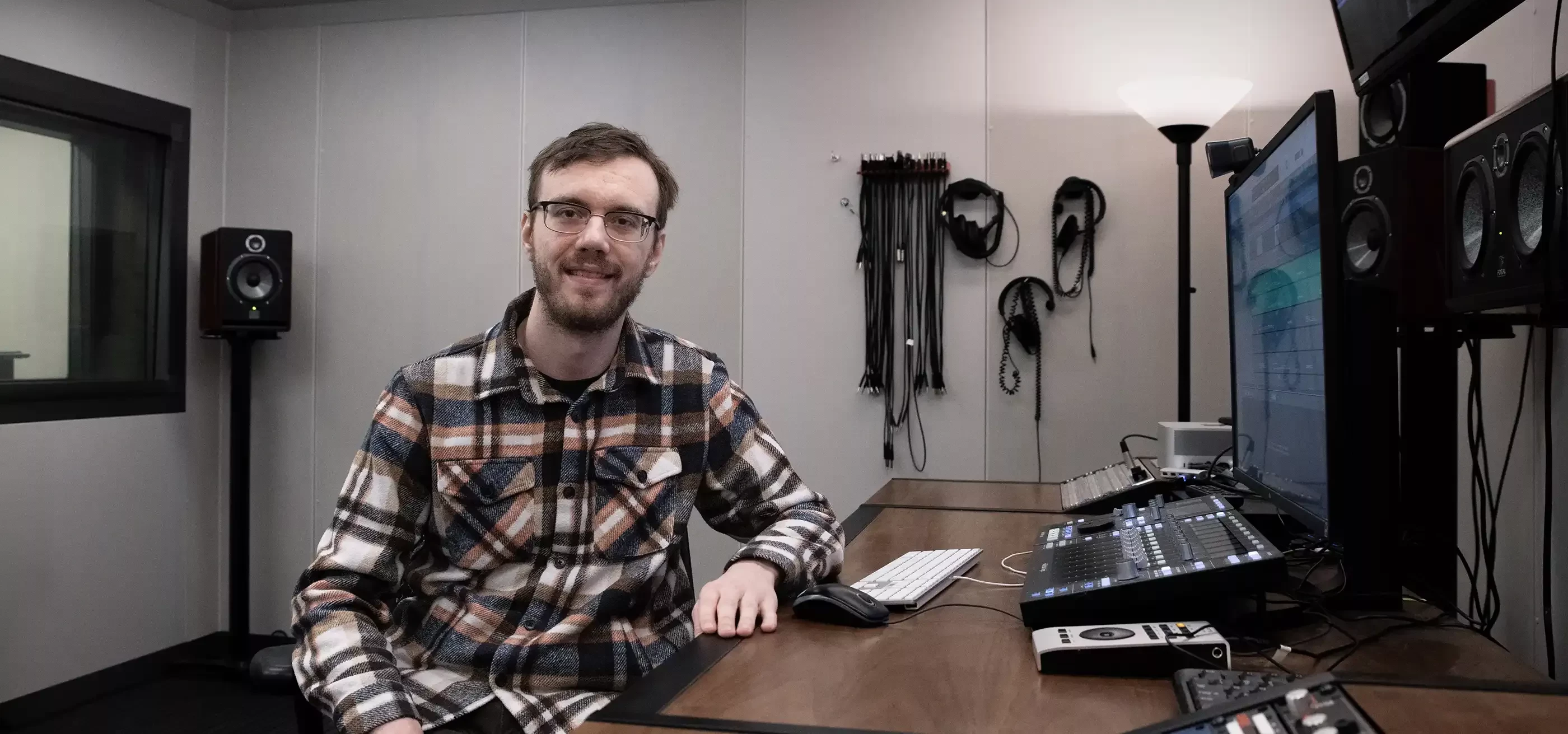 Caleb Klomparens sits at an audio workstation.
