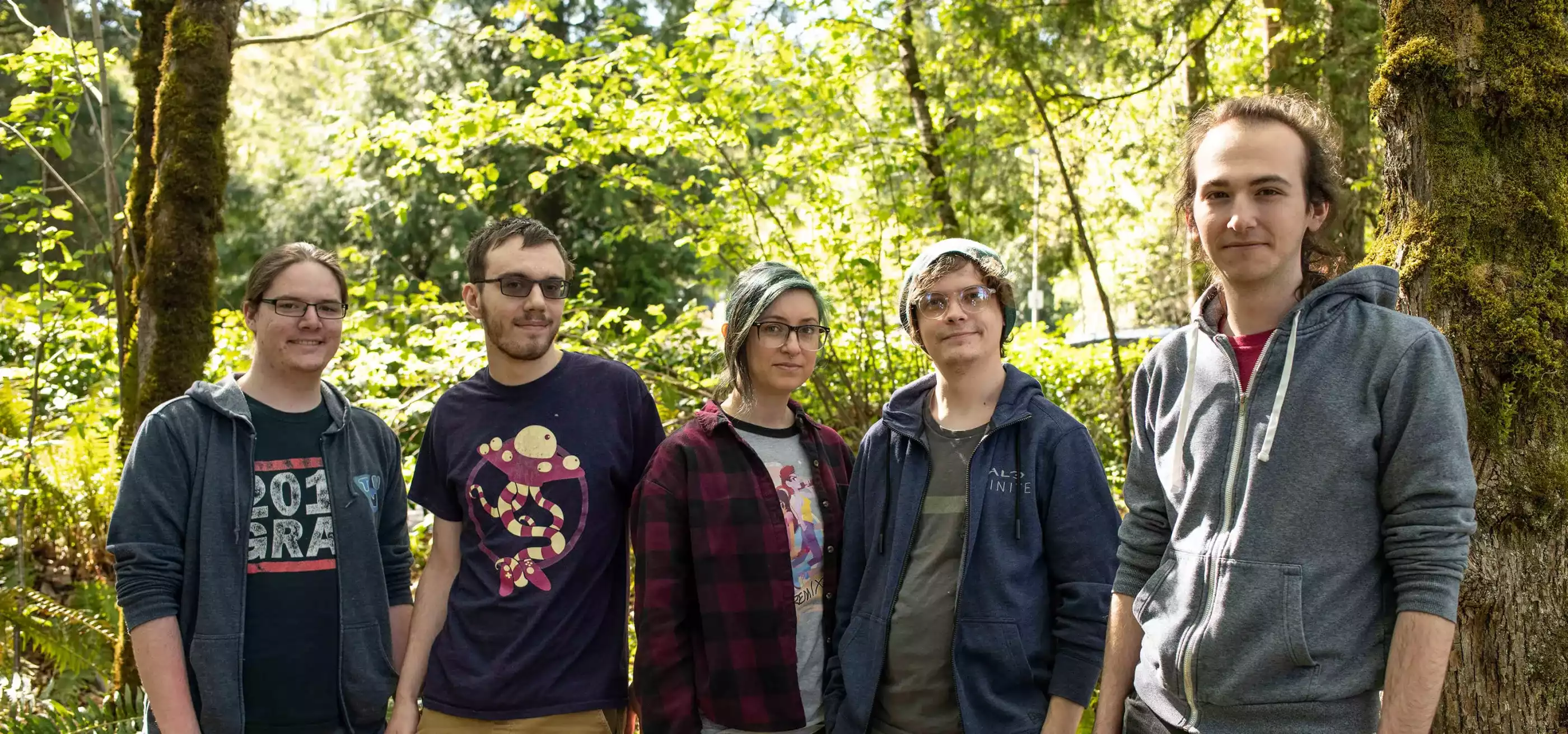 Student game team Free Minds poses in front of the Redmond forests that inspired The Pilgrim.