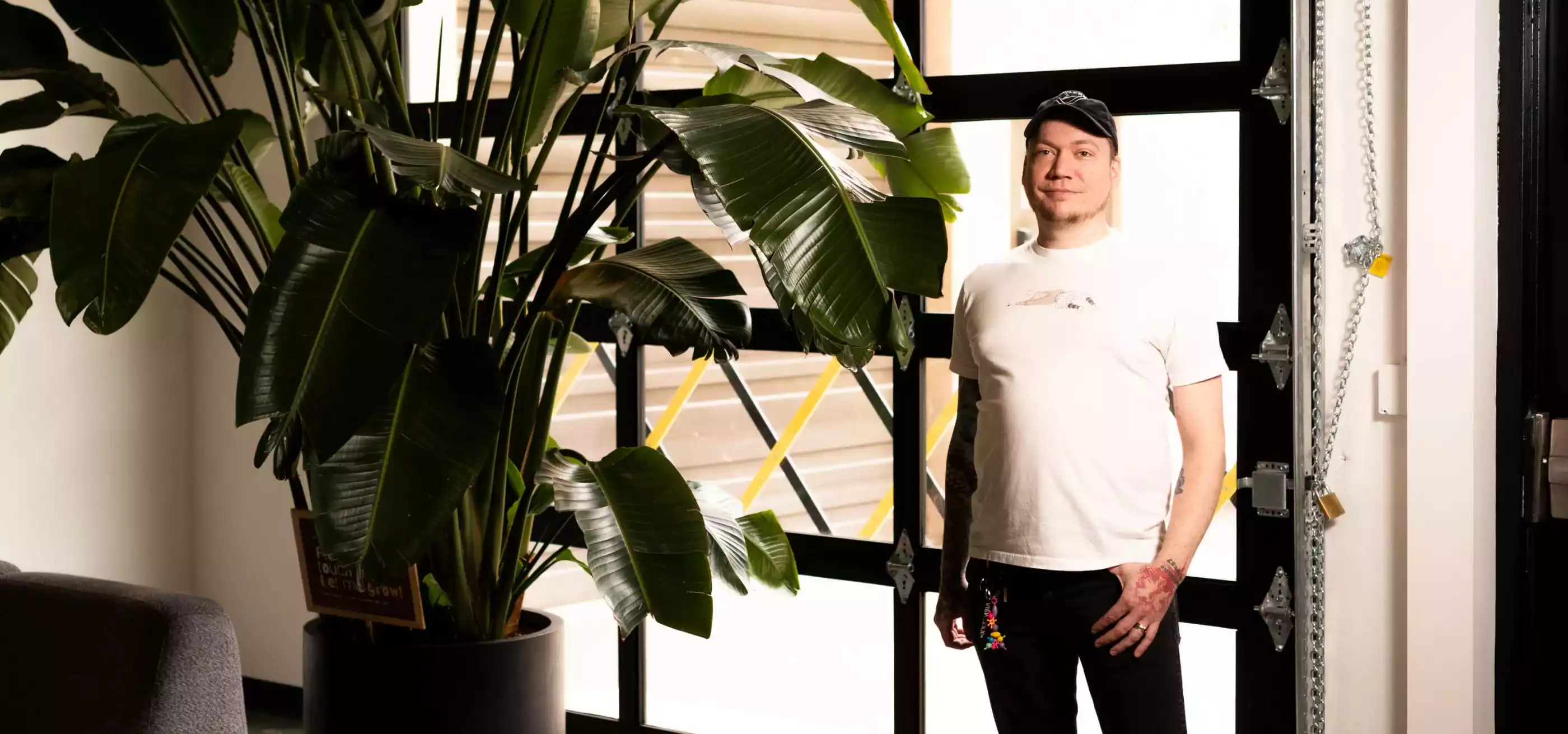 Pat Jandro poses next to a large potted plant in front of a bay door.